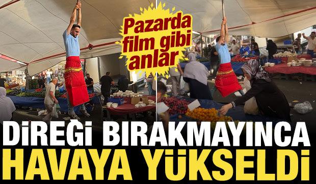 Kuvvetli r&uuml;zgarda pazarcı branda direğini bırakmadı, metrelerce havaya y&uuml;kseldi